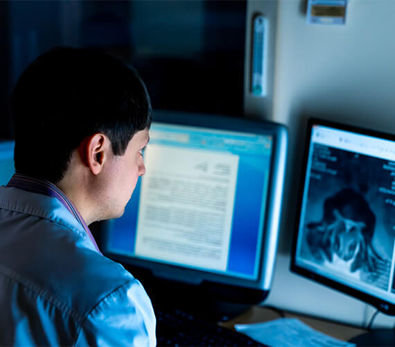 radiologist sitting in front of a computer